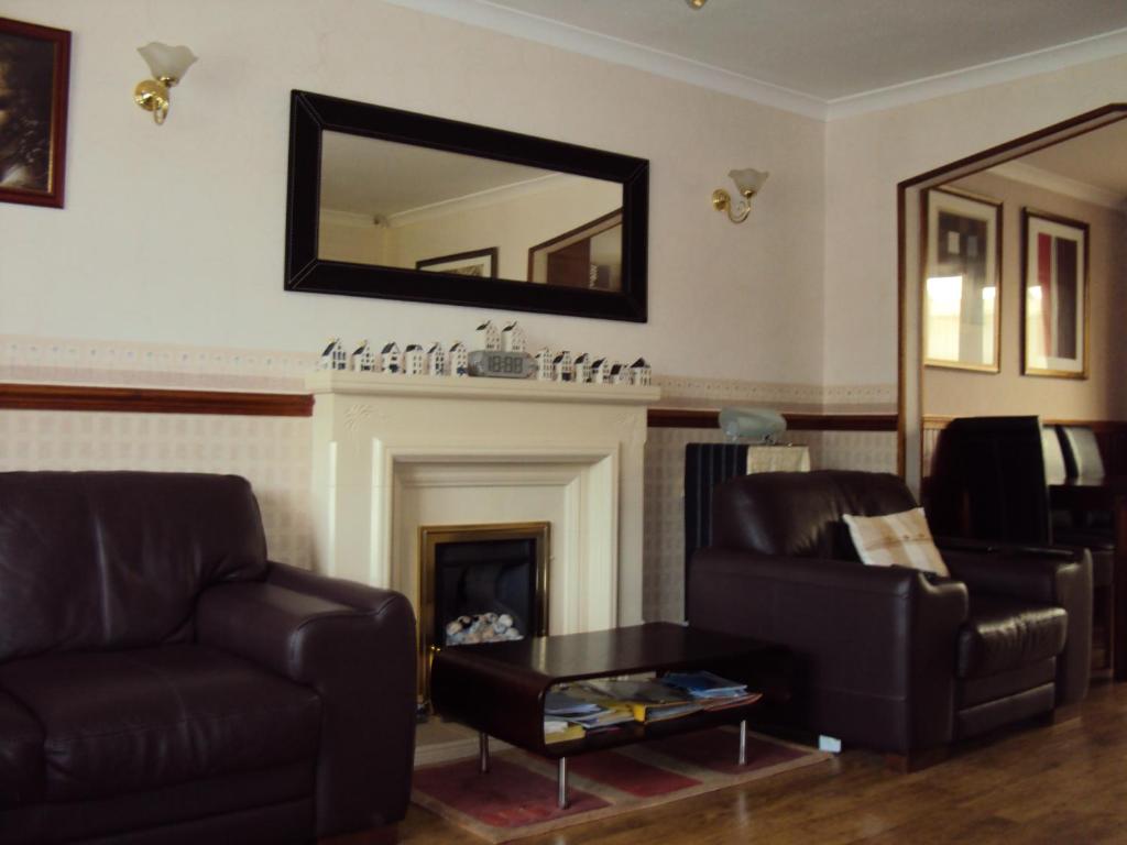 uma sala de estar com um sofá e uma lareira em Birchwood Private Room for Homestay em Risley