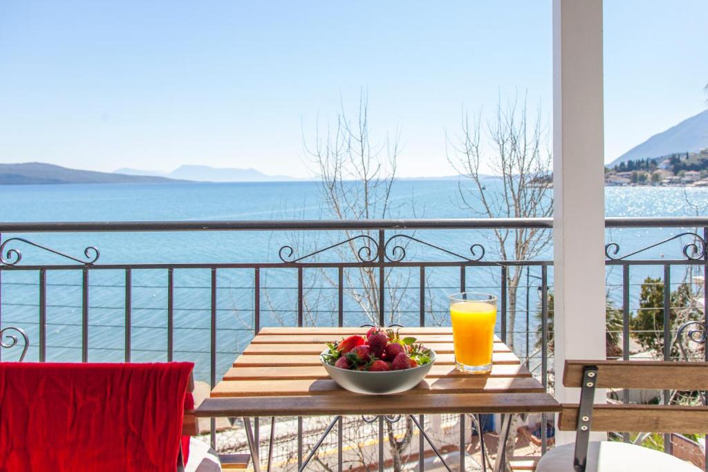 a table with a bowl of fruit and a glass of orange juice at Ligia Waterfront Apartments in Lygia