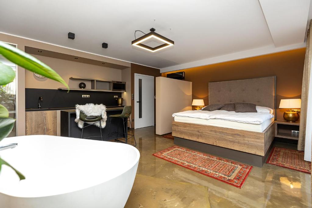 uma casa de banho com uma cama e uma banheira num quarto em Apartmány U Vinice em Pardubice