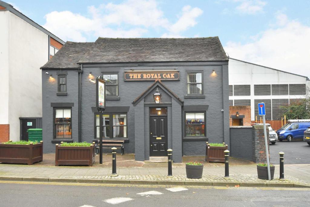 a black building with a sign that reads the town cafe at The Royal Oak in Biddulph