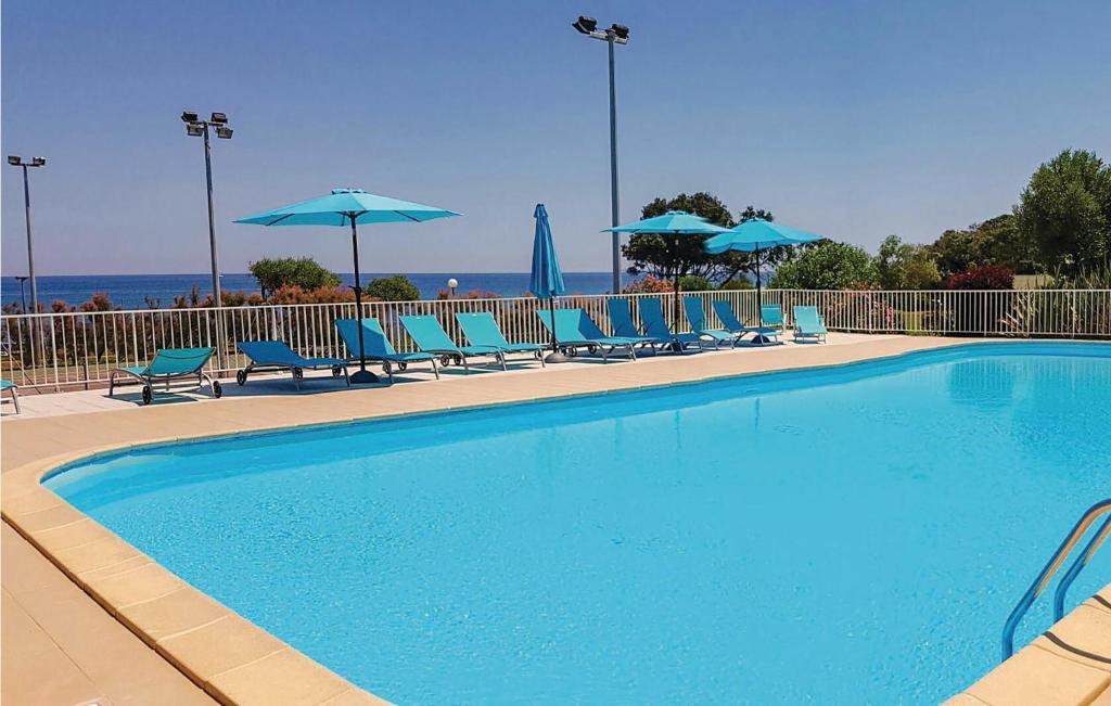 - une piscine avec des chaises et des parasols bleus dans l'établissement studio à 100m de la plage et de la piscine, à Cervione