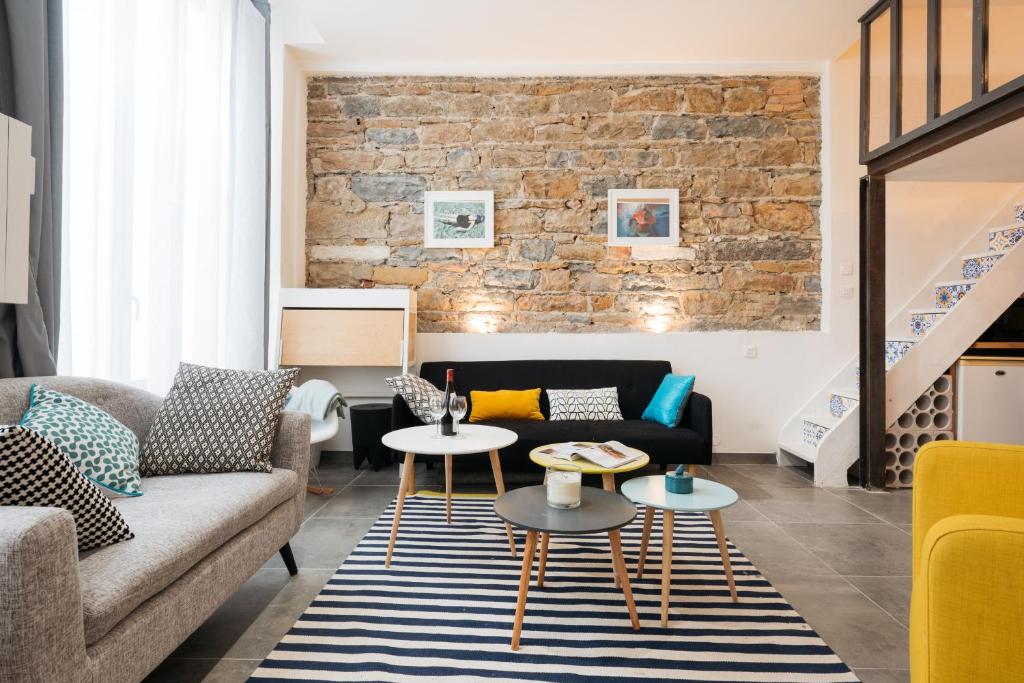 uma sala de estar com um sofá e mesas em Dify Vaudrey - Part Dieu em Lyon