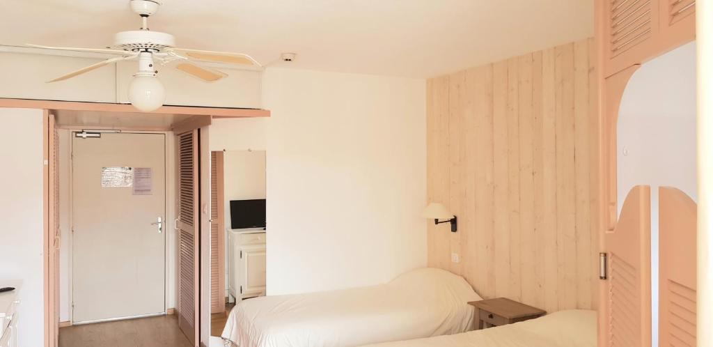 sypialnia z 2 łóżkami i wentylatorem sufitowym w obiekcie Résidence du Bois de Lon w mieście Lamalou-les-Bains