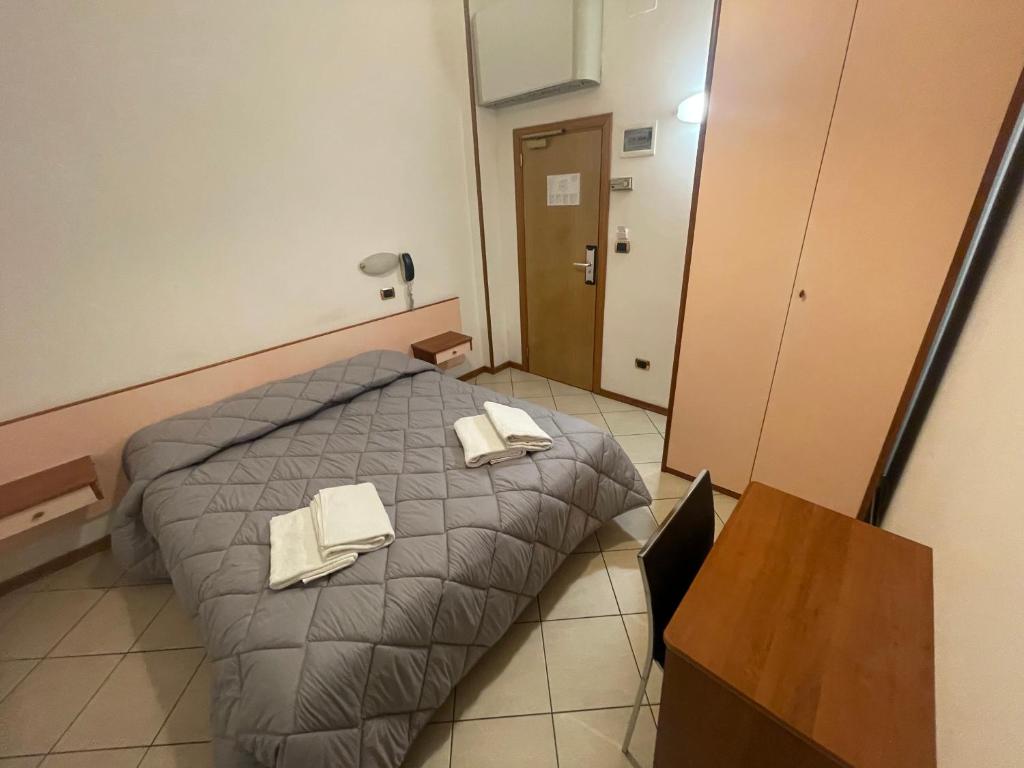 sypialnia z łóżkiem z dwoma ręcznikami w obiekcie Hotel Manola w Rimini