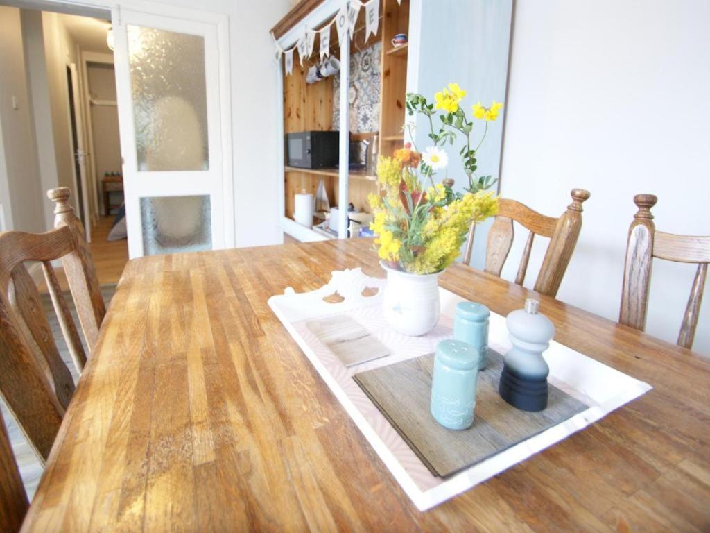 a dining room table with a vase of flowers on it at Florita - Dawlish in Dawlish