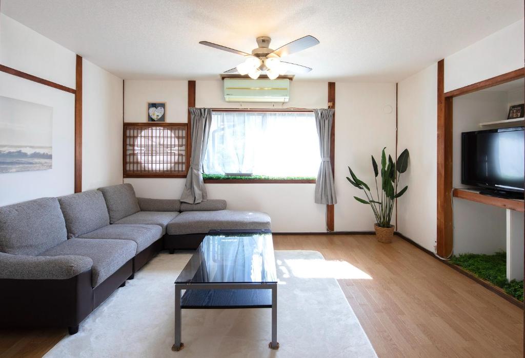 a living room with a couch and a tv at Wぴーす（W PEACE) in Fukuchiyama