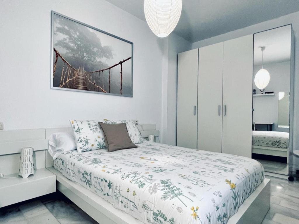 ein Schlafzimmer mit einem Bett mit einem Brückenbild an der Wand in der Unterkunft Apartamento Pintor Palomino in Córdoba