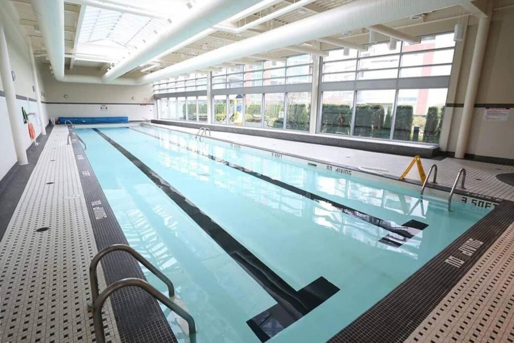 a large indoor swimming pool with blue water at Beautiful 1 BR in the Heart of Downtown: Parking, Pool & Gym in Vancouver