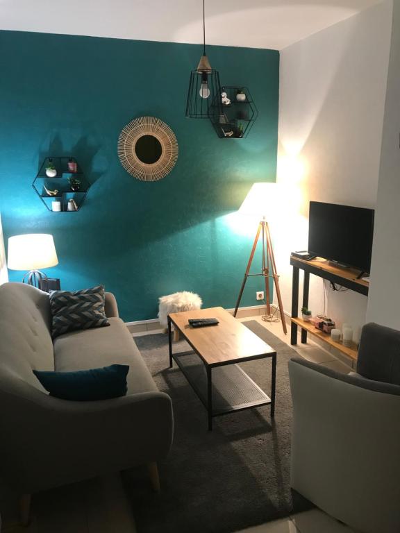a living room with a couch and a table at Le bien venue chez vous in Calais