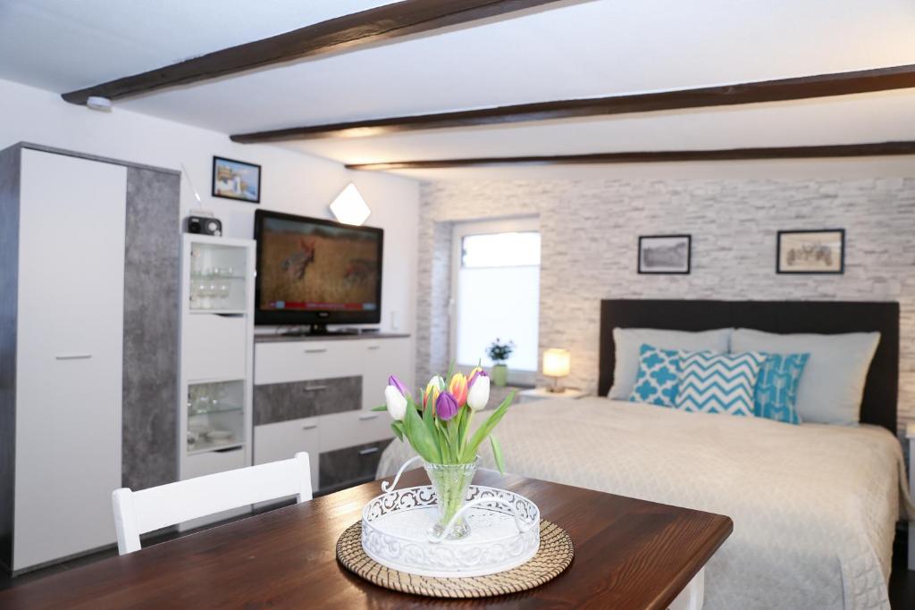 a bedroom with a bed and a table with flowers on it at Schlossweg-Apartment in Blankenburg