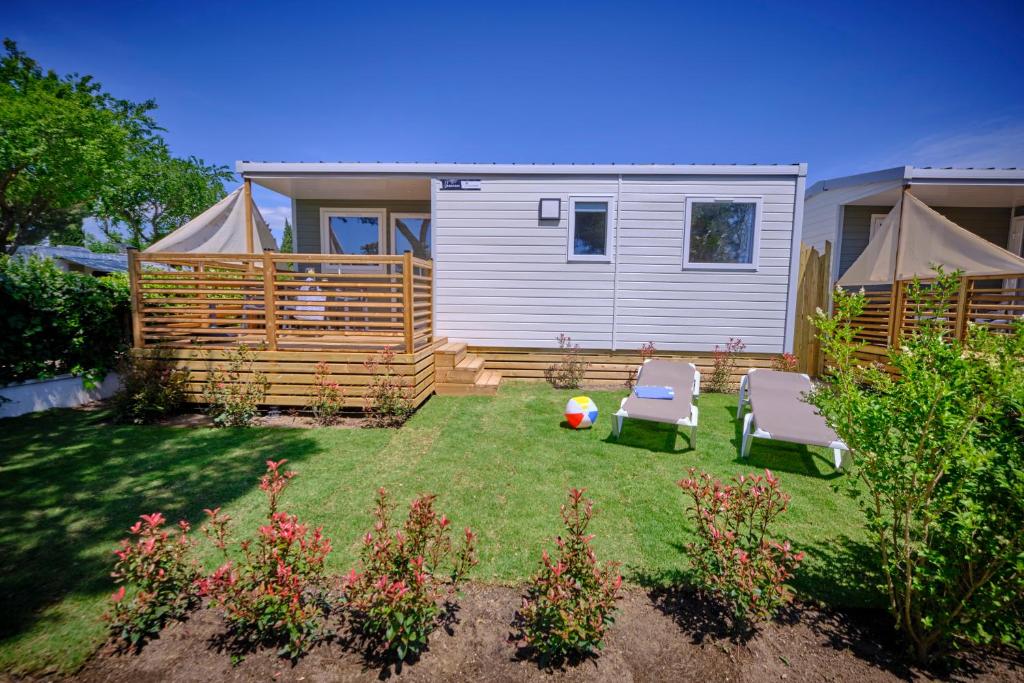 een kleine tuin met twee stoelen en een huis bij Camping Rodas in Roses