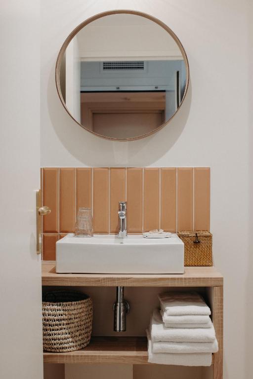 a bathroom with a sink and a mirror at Hôtel PALMITO in Biarritz