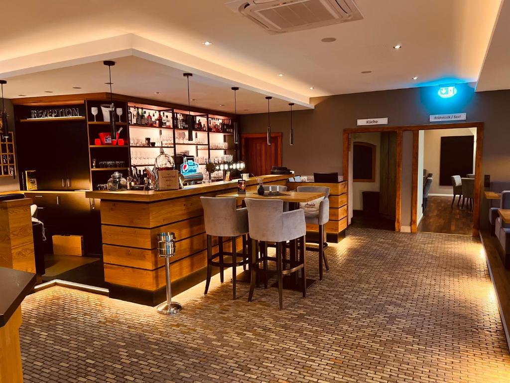 a bar in a restaurant with stools at a counter at Hotel Dülmener Hof in Dülmen