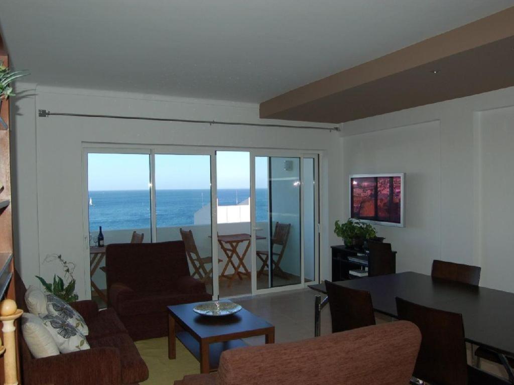 uma sala de estar com vista para o oceano em Apartamento a 10 metros da praia de Albufeira em Albufeira
