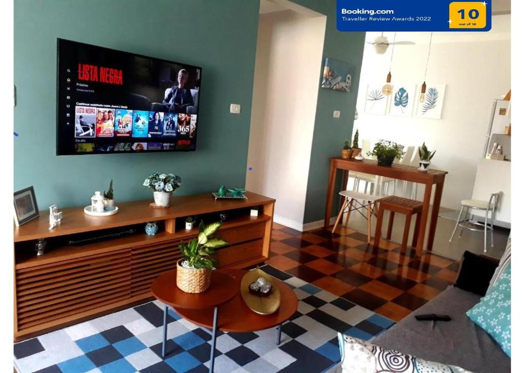 a living room with a flat screen tv on a wall at APARTAMENTO PRAIA GRANDE-CANTO DO FORTE- 2 QUADRAS DA PRAIA WI-FI,NETFLIX e ESTACIONAMENTO in Praia Grande