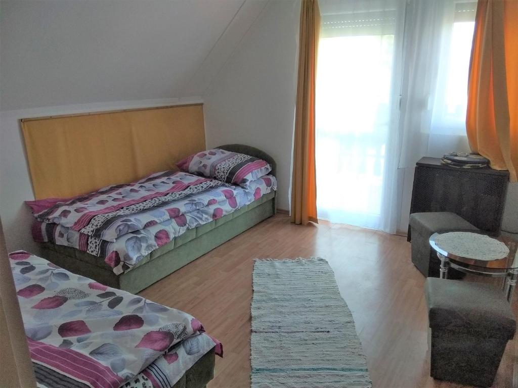 - une chambre avec 2 lits jumeaux et une fenêtre dans l'établissement Hanga Apartman, à Balatonlelle