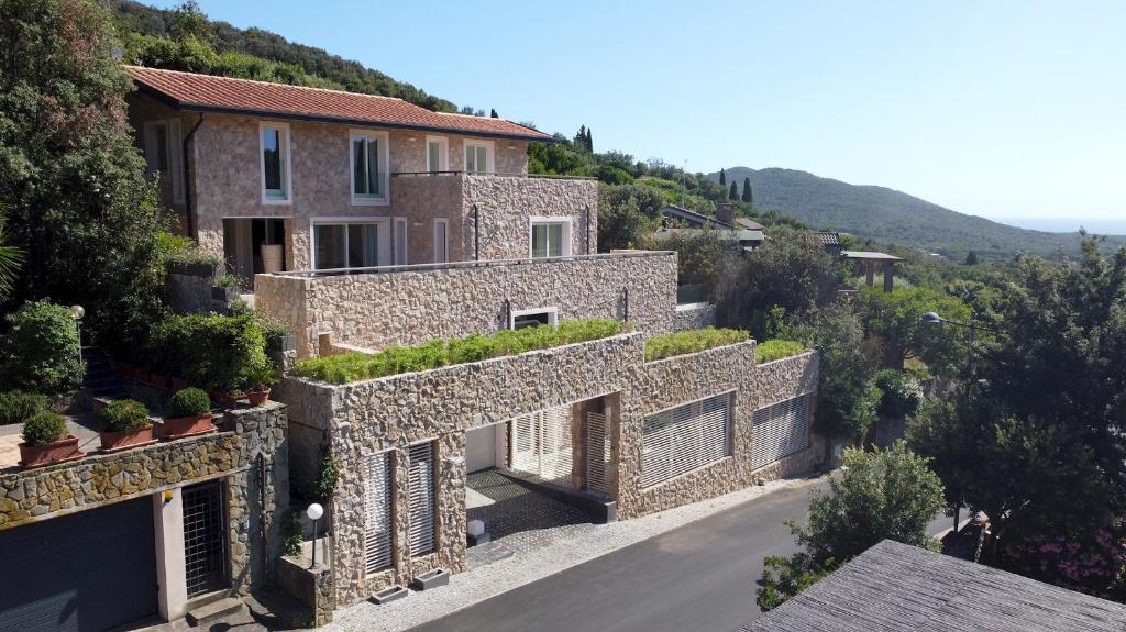 ein Steinhaus auf einem Hügel mit einer Straße in der Unterkunft VILLA LE MANDRIE 7&2, Emma Villas in Castiglione della Pescaia