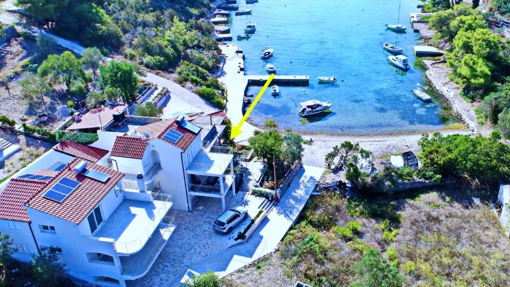 une vue aérienne sur une maison avec des bateaux dans l'eau dans l'établissement Apartment Slatina Bay, à Vela Luka