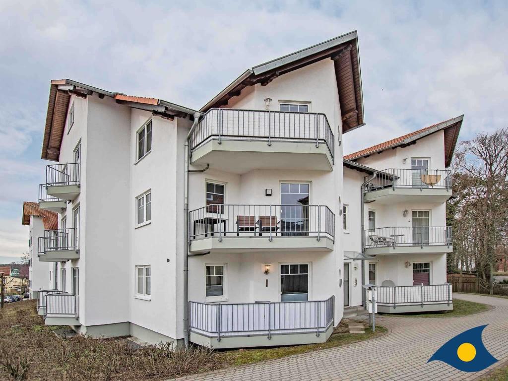 un edificio blanco con balcones en un lateral en Ferienwohnung Strandstuuv _ Whg_ 16, en Ahlbeck