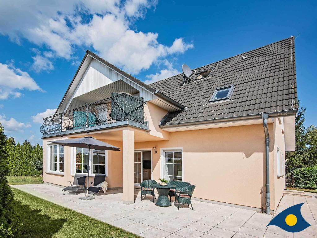 a house with a balcony and a patio at Haus Achterwasserblick in Ueckeritz