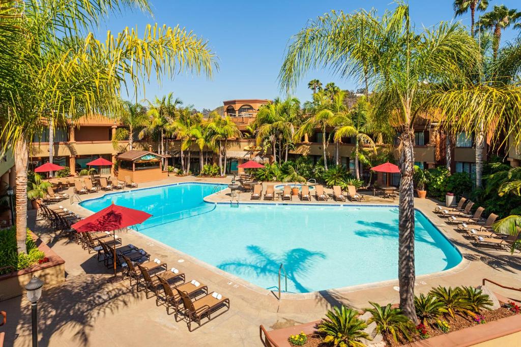 a pool at a resort with palm trees and umbrellas at Handlery Hotel San Diego in San Diego