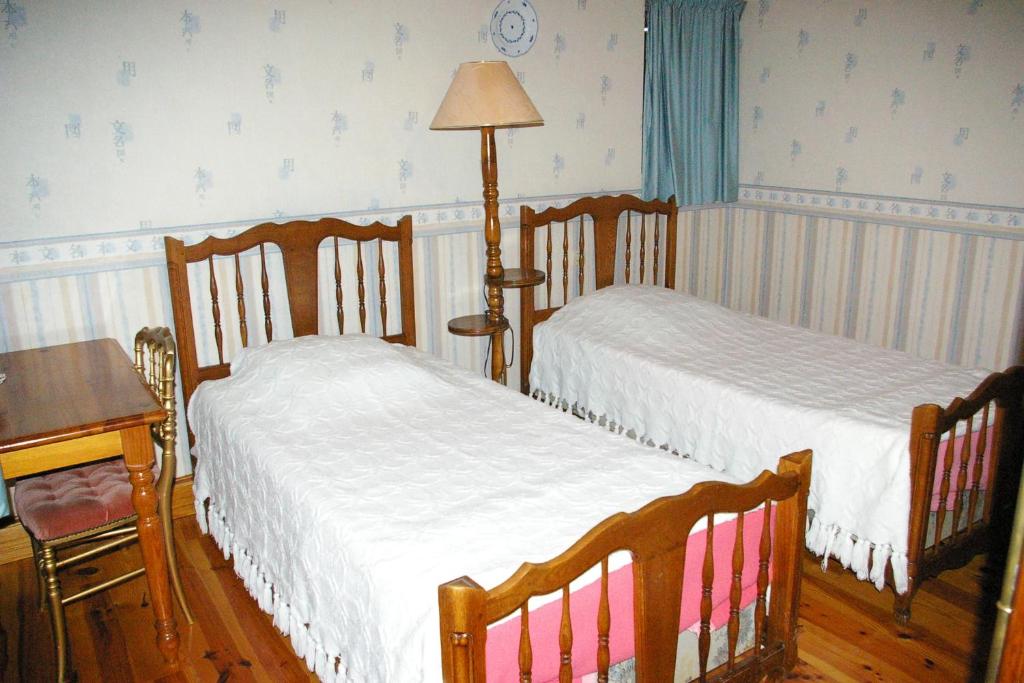 1 dormitorio con 2 camas y mesa con lámpara en Chambres d'Hotes du Maine, en Lalinde