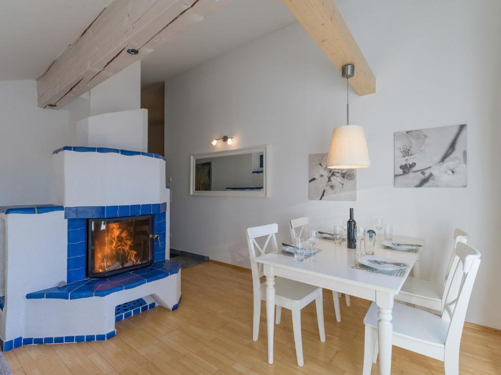 a living room with a fireplace and a table and chairs at Ski-in, Ski-out by Apartment Managers in Kirchberg in Tirol