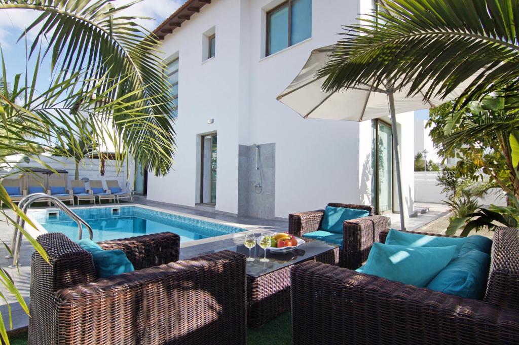 een terras met stoelen en een zwembad bij Villa Serena in Protaras