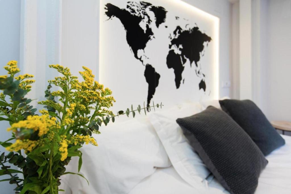 un sofá blanco con un mapa del mundo en la pared en GoToSeville Molviedro Apartments, en Sevilla