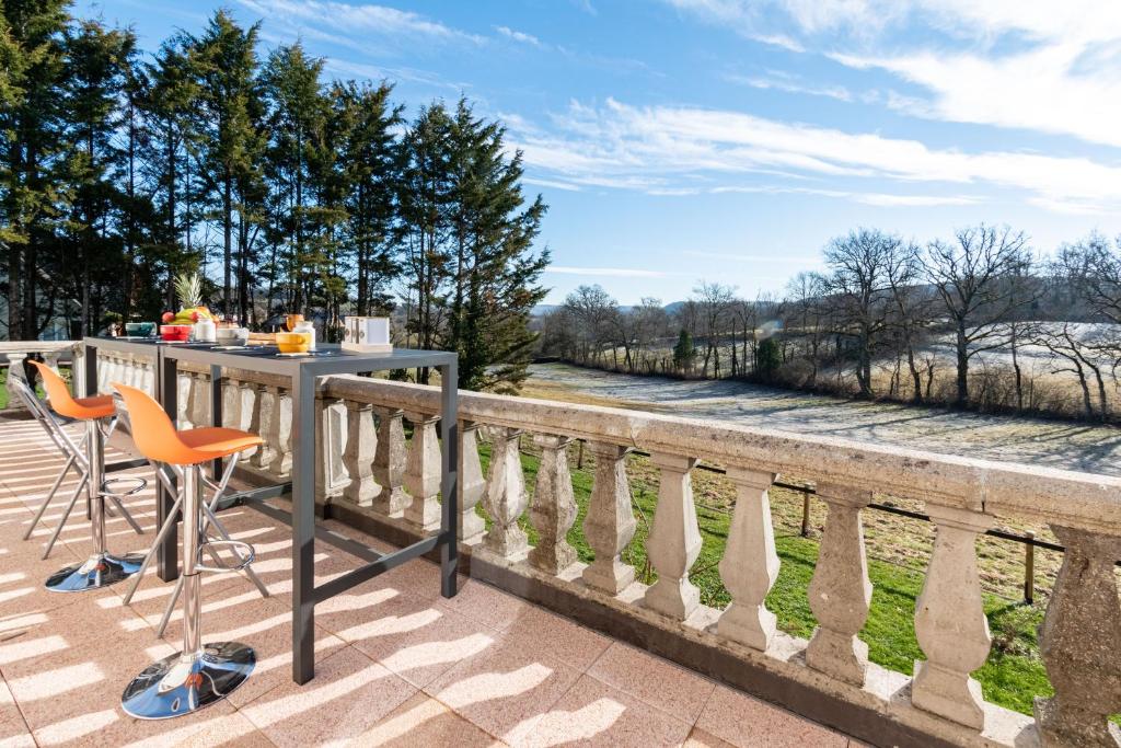 - Balcón con mesa y sillas y vistas al río en Gîte le Couderc, en Gabriac