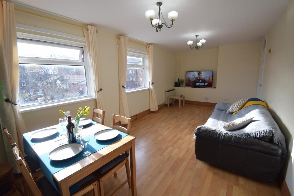 een woonkamer met een bank en een tafel bij Prime Location Apartment in Belfast