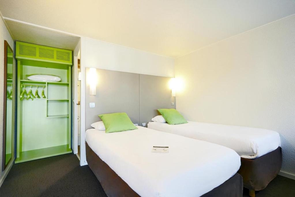 two beds in a small room with green accents at Campanile Auxerre - Monéteau in Monéteau
