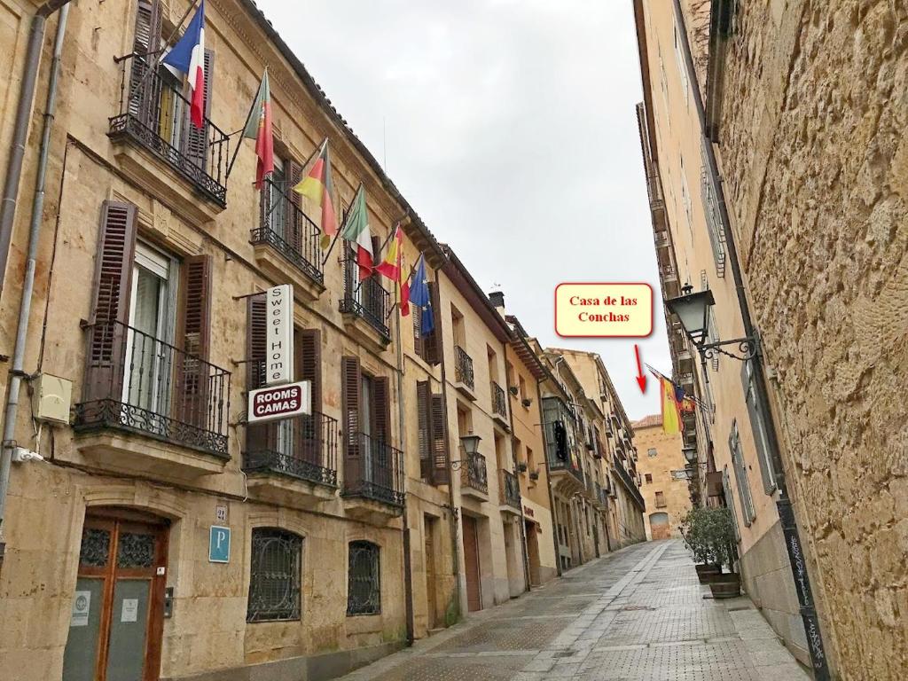 una calle vacía con banderas al lado de los edificios en Sweet Home Salamanca, en Salamanca
