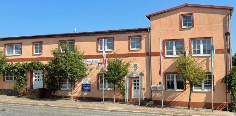 un grand bâtiment en briques sur le côté d'une rue dans l'établissement Hotel-Restaurant Christine, à Lübz