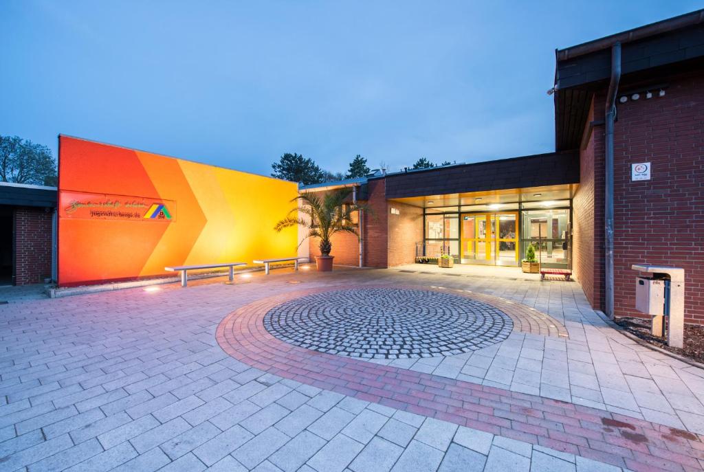 a building with a patio with benches in front of it at Jugendherberge Cuxhaven in Cuxhaven