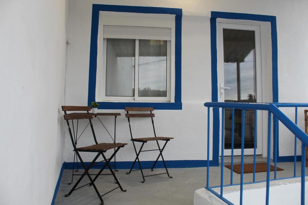 Amiães de BaixoにあるAmiais River Beach Houseの椅子2脚と窓が備わる客室です。