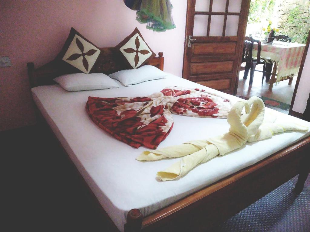 a bedroom with a large bed with white sheets at Ella Summer Lesser in Ella