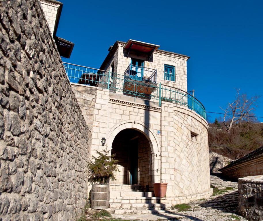 un edificio de piedra con balcón en la parte superior. en Napoleon Zaglis Guesthouse, en Kalarites