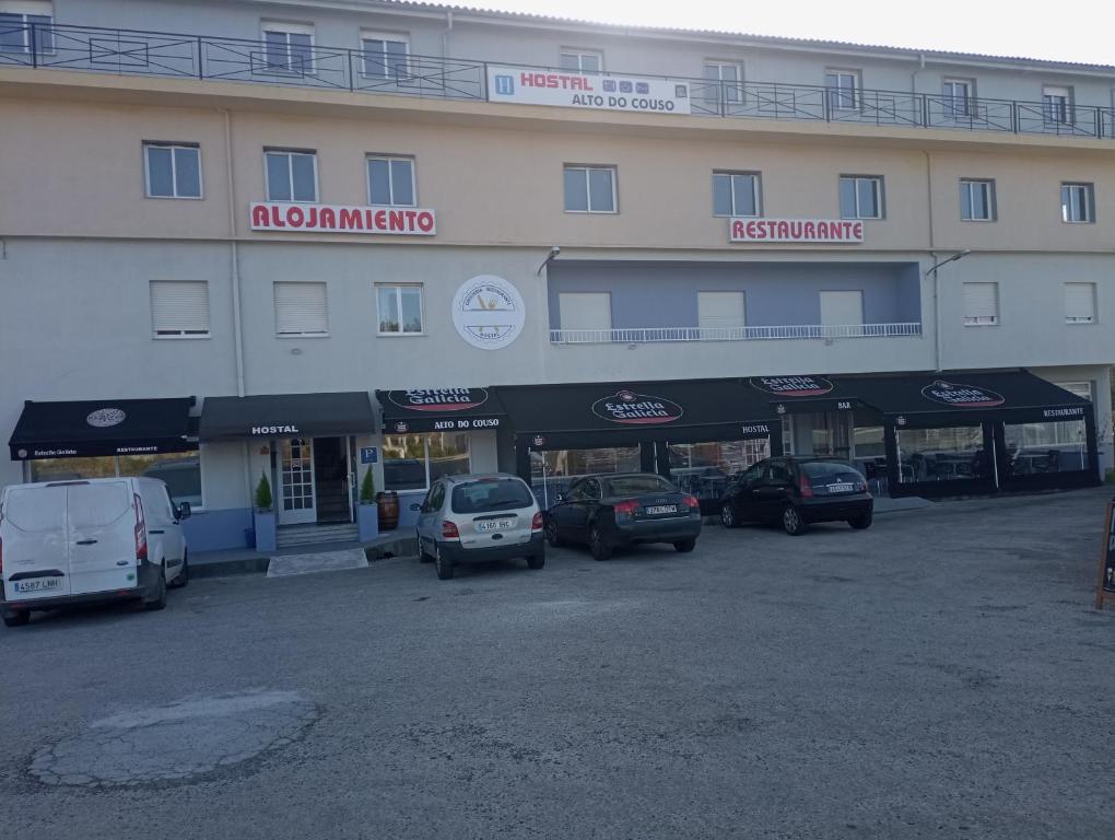 ein großes Gebäude mit Autos auf einem Parkplatz in der Unterkunft O novo alto do couso in Ourense