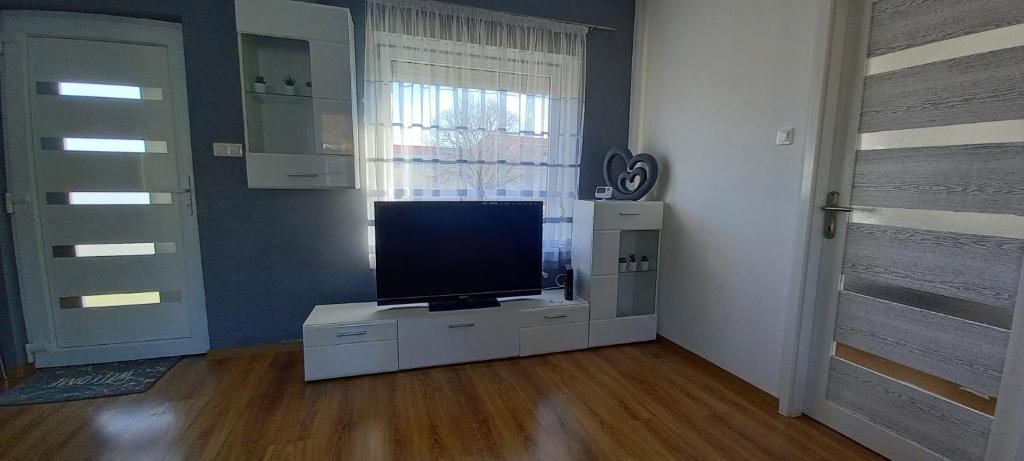 a living room with a television on a white cabinet at BE-LE-VALÓ APARTMAN in Szécsény