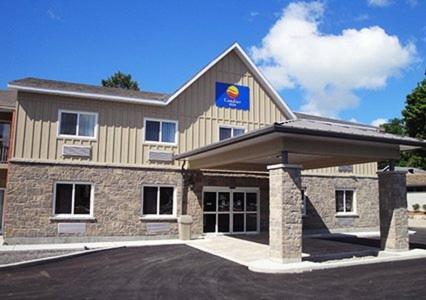 a building with a flag on the front of it at Comfort Inn & Suites Thousand Islands Harbour District in Gananoque