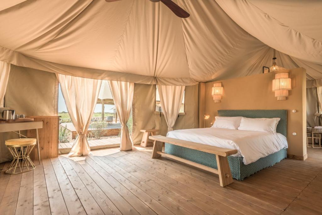ein Schlafzimmer mit einem Bett in einem Zelt in der Unterkunft Terme di Vulci Glamping & Spa in Canino
