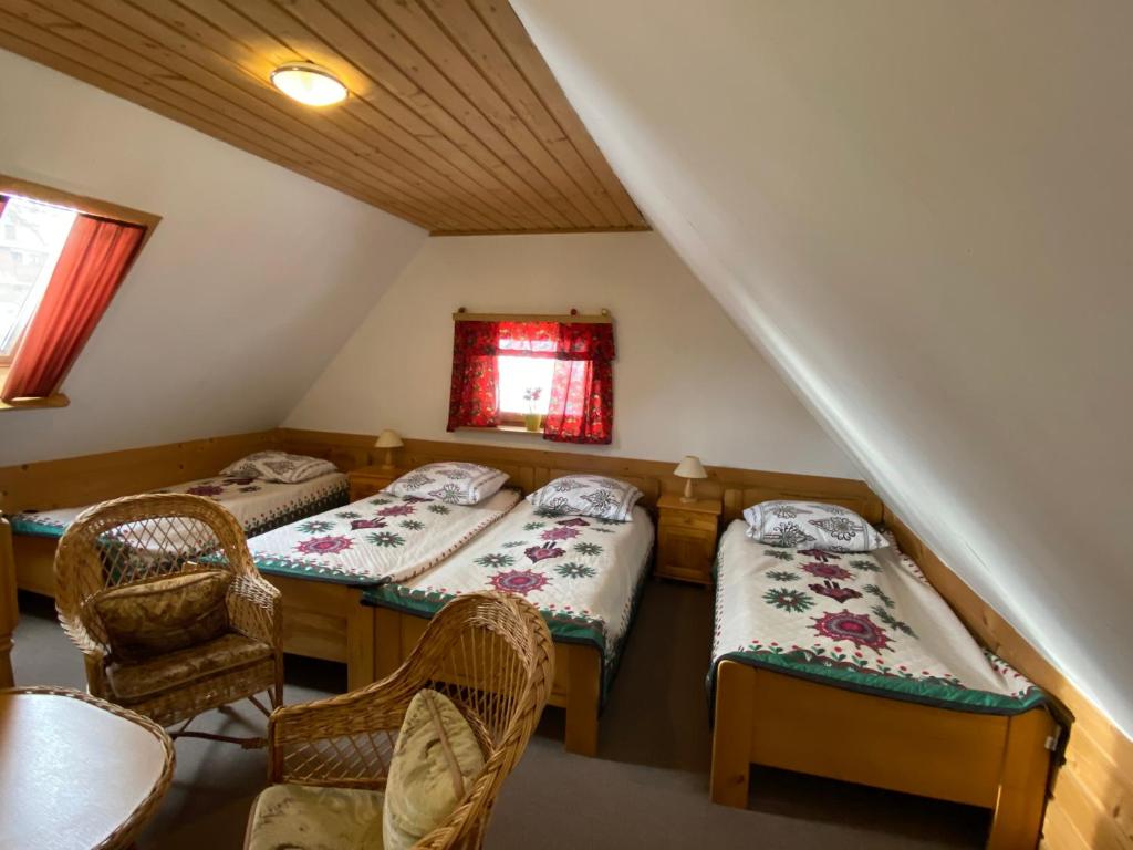 Cette chambre comprend deux lits, une table et des chaises. dans l'établissement Domki Camping Harenda, à Zakopane