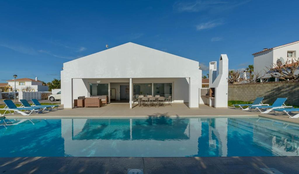 eine Villa mit einem Pool neben einem Haus in der Unterkunft Villa Son Blanc Grupo Seranova Luxury Hotel in Sa Caleta