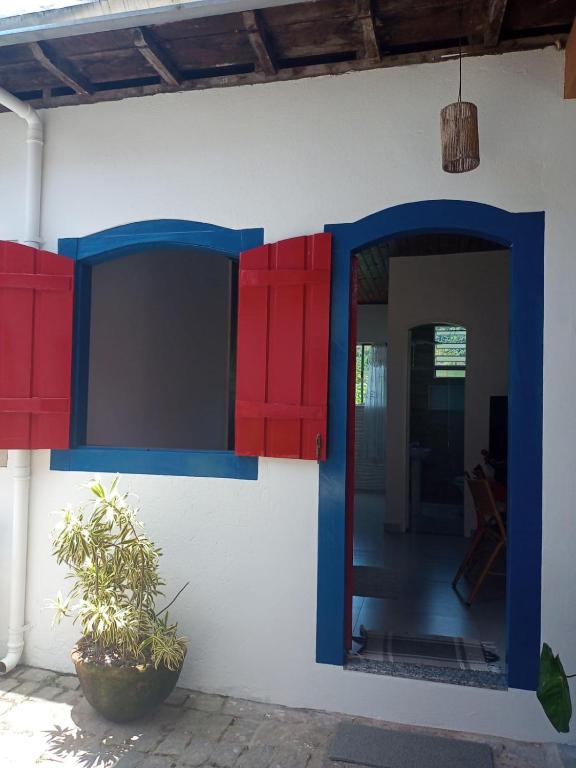 a house with red and blue doors and a window at Pousada Refúgio Ouro Fino - Flats & Suítes in Paraty