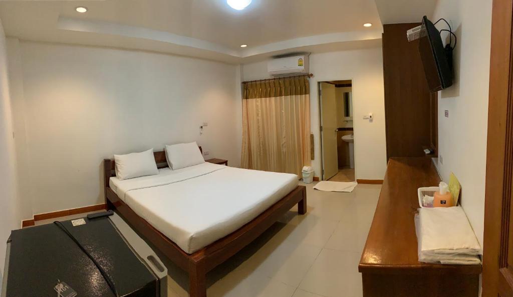una camera da letto con un letto e una televisione di SB Mansion a Buriram