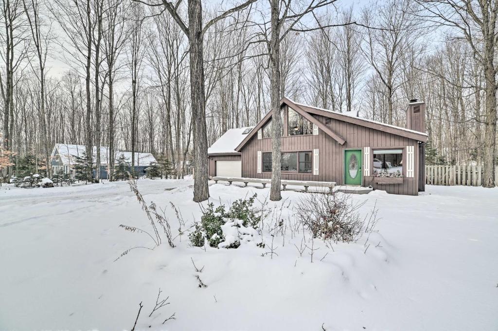 a small house in the snow in a yard at Harbor Springs Rental Home Swim and Boat Nearby! in Harbor Springs