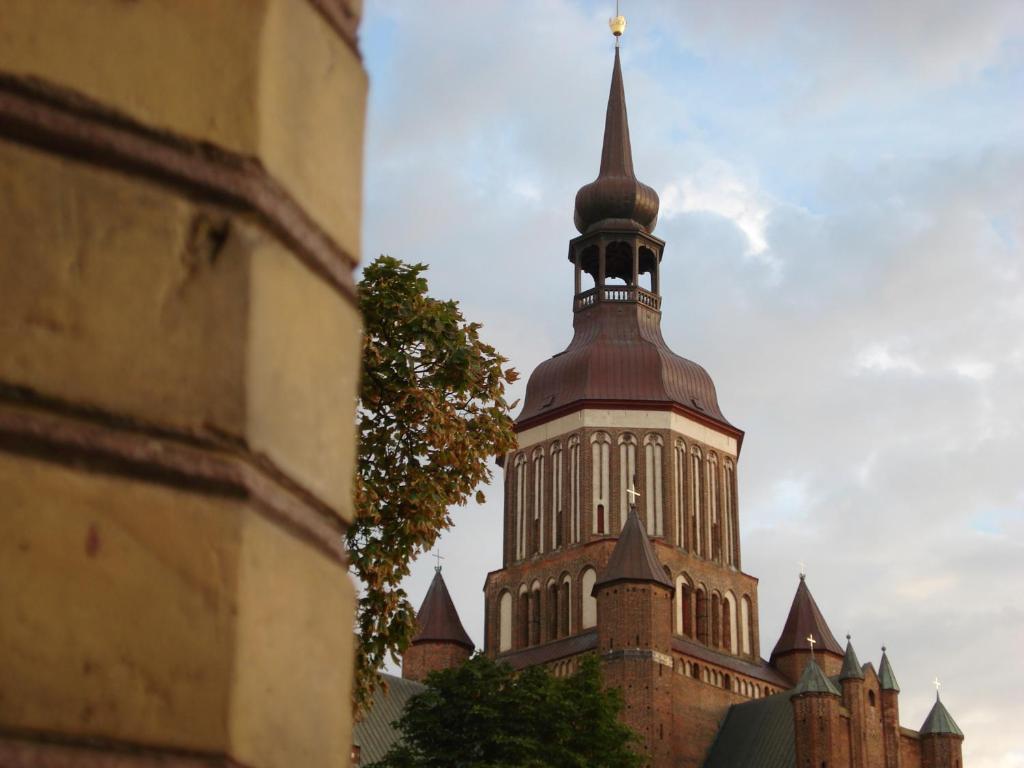 d'un grand bâtiment avec une cloche en haut. dans l'établissement City Apartments Altstadt Stralsund, à Stralsund