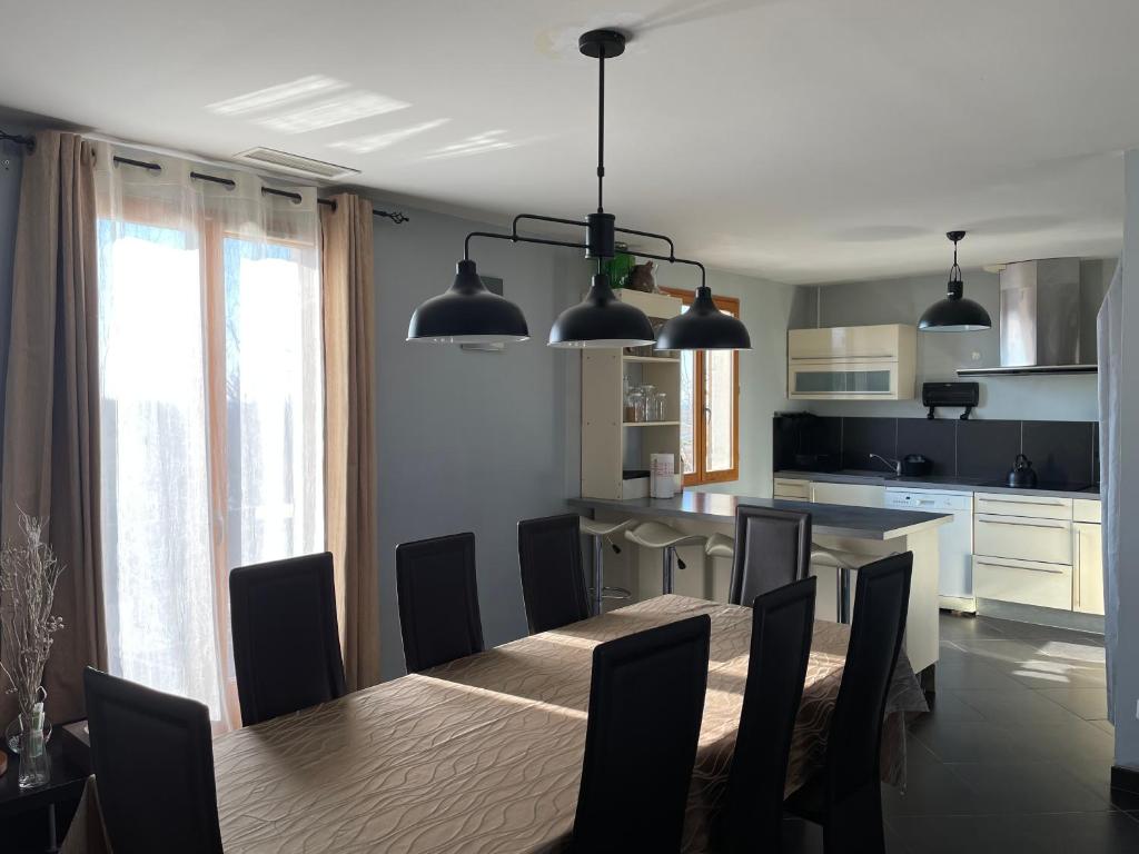 a kitchen and dining room with a table and chairs at Petite maison en pleine campagne in Labastide-Gabausse