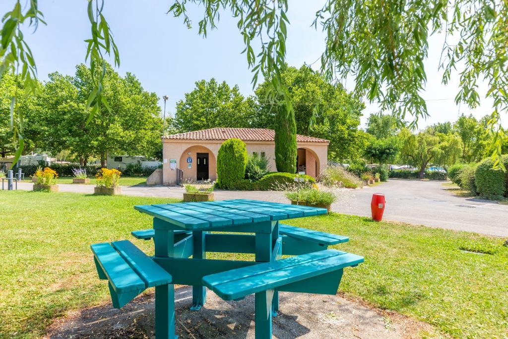 un groupe de tables de pique-nique dans un parc dans l'établissement Camping Sites et Paysages Les Prés Hauts, à Sisteron